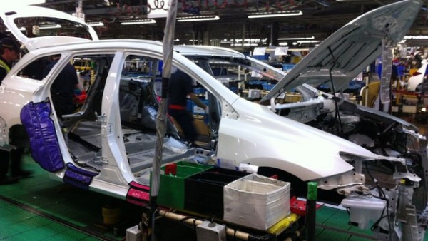 An Auris Touring Sports shell leaves the press and paint facility and joins the assembly track.
